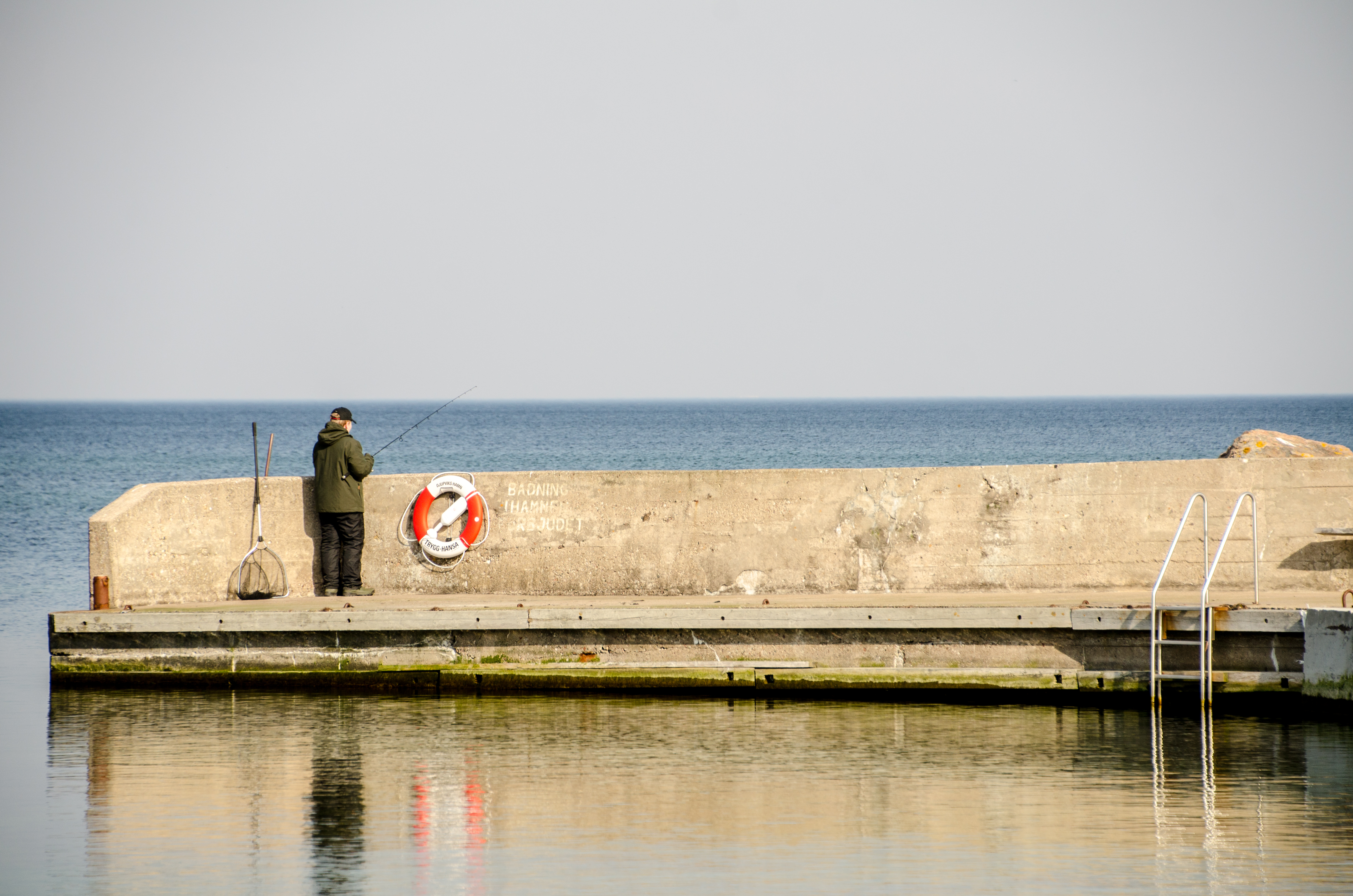 Man som fiskar vid hamnen 2